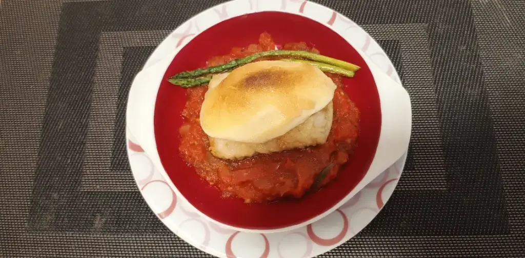 un plato con la receta de bacalao con muselina de ajo